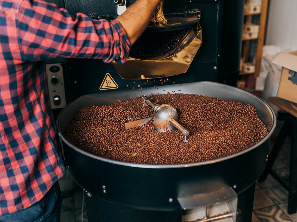 homme tenant des grains de café aromatiques