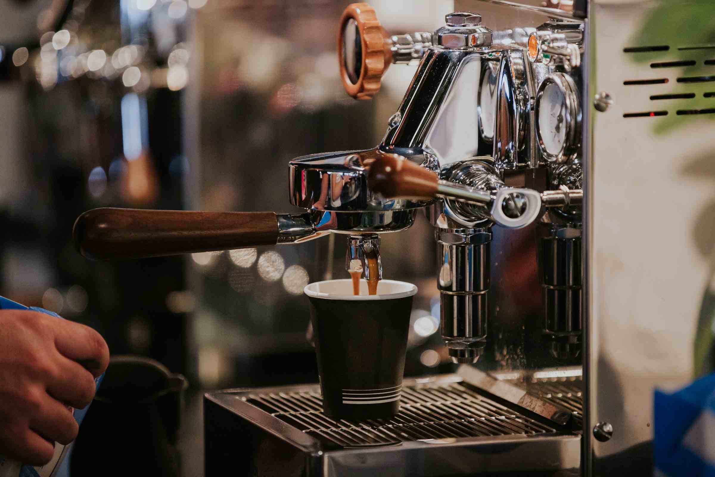 Machine à café professionnelle utilisée par un barista qui fait couler du café 
