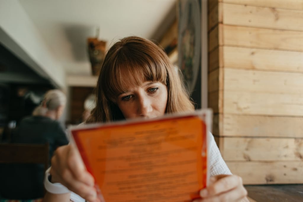 Femme Tenant une carte des cafés